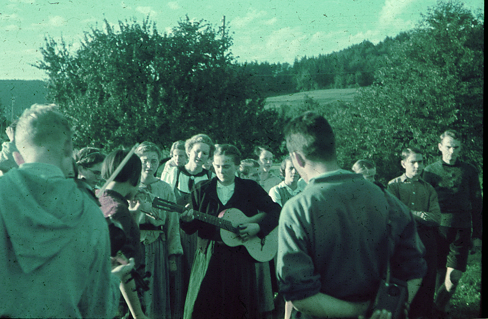 Gruppe von Wandervögeln im Freien: Mädchen Gitarre spielend, Junge Geige spielend