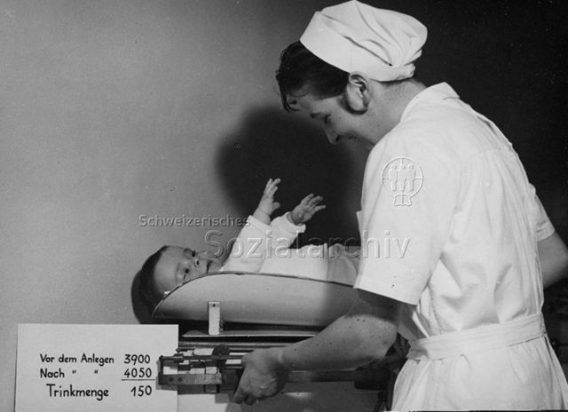 Frau wiegt Säugling; um 1965