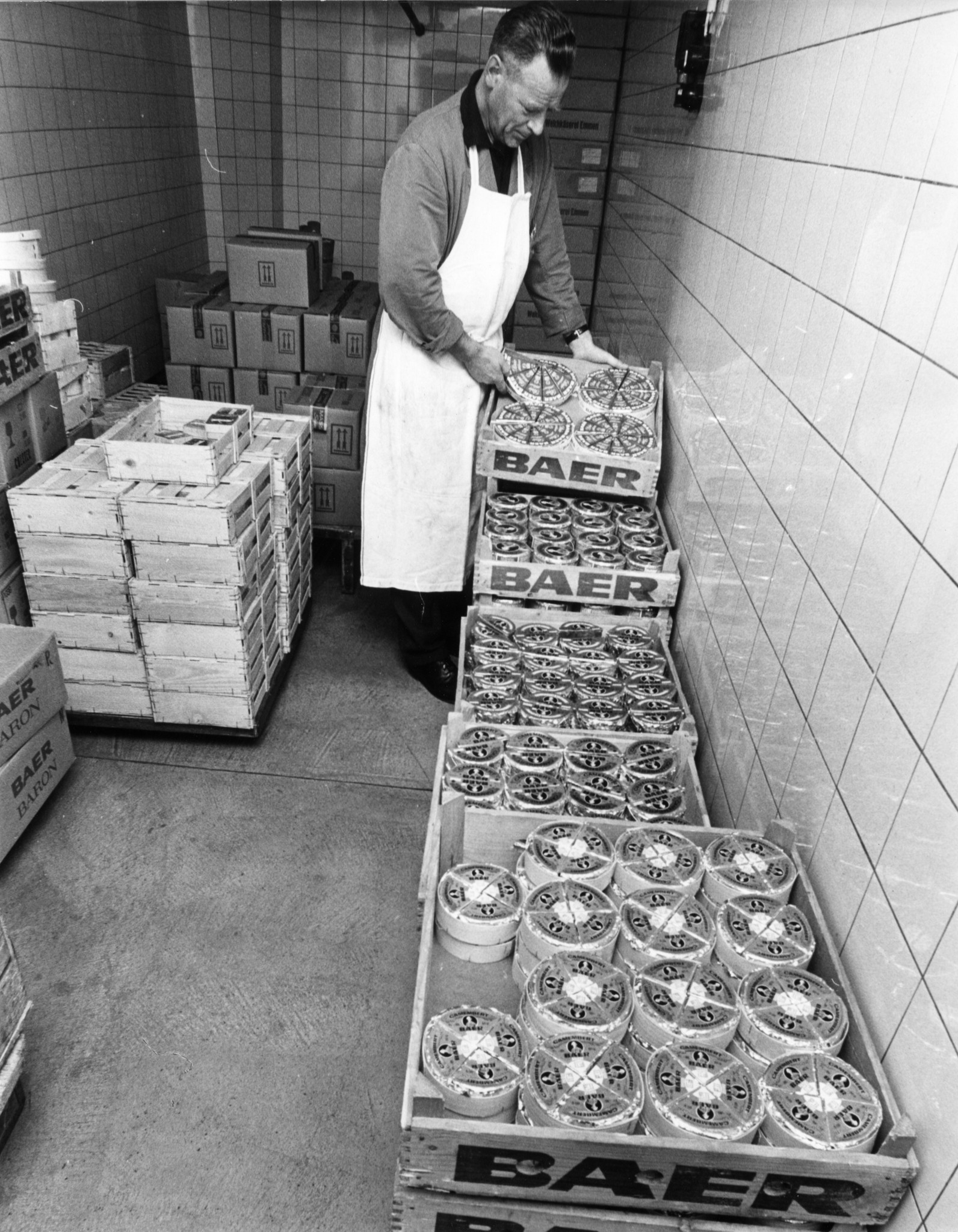 Mann beim Stapeln von Kisten mit verpacktem Käse der Marke Baer