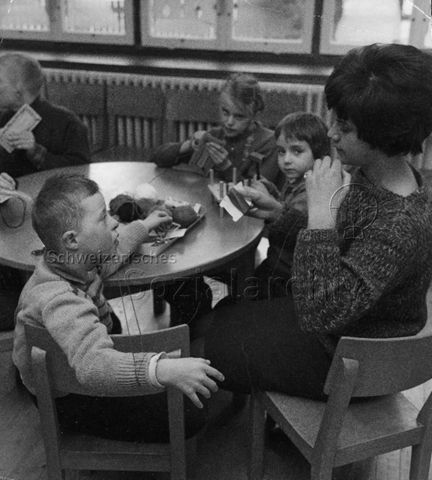 Frau und Kinder bei Textilarbeiten; um 1970