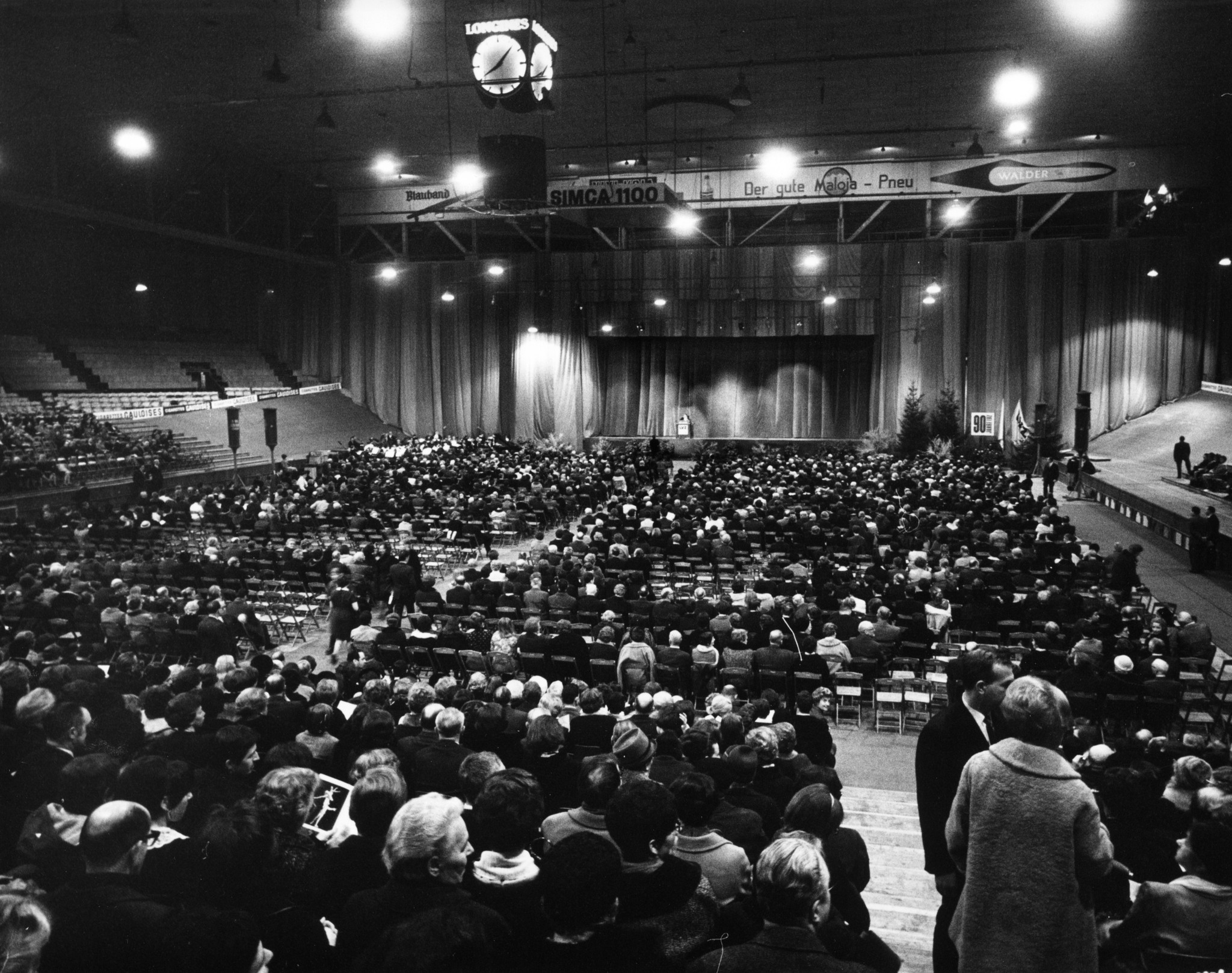 Jubiläum 90 Jahre Lebensmittelverein Zürich 1968: Aufnahme der Besucher auf Sitzreihen und die Bühne mit Redner im Hallenstadion Zürich