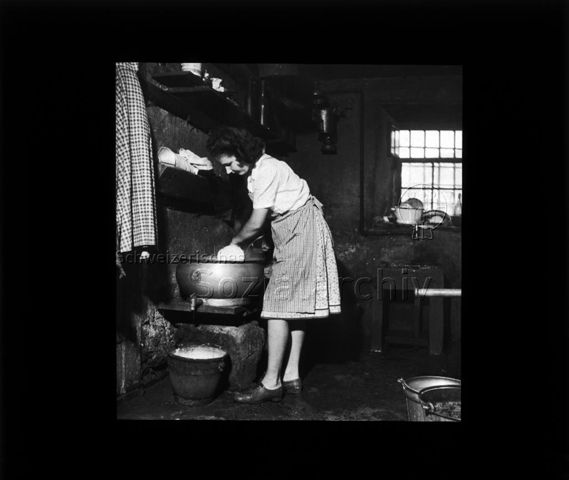 Diaserie "Reserve" und "alte Dias"; eine Frau bei der Weiterverarbeitung von Milch, wahrscheinlich mit einem Milchseperator ; um 1950