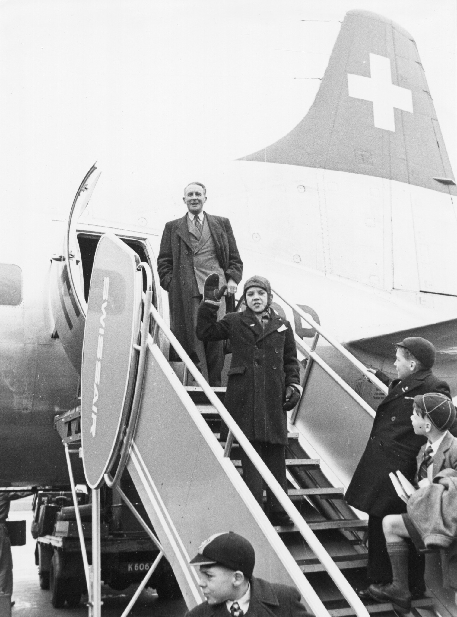 Knabe winkt vor dem Einstieg ins Flugzeug