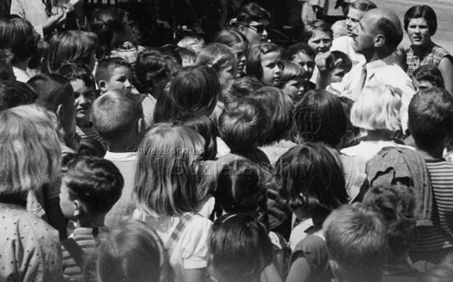 Mann spricht zu einer Gruppe Kinder; um 1970
