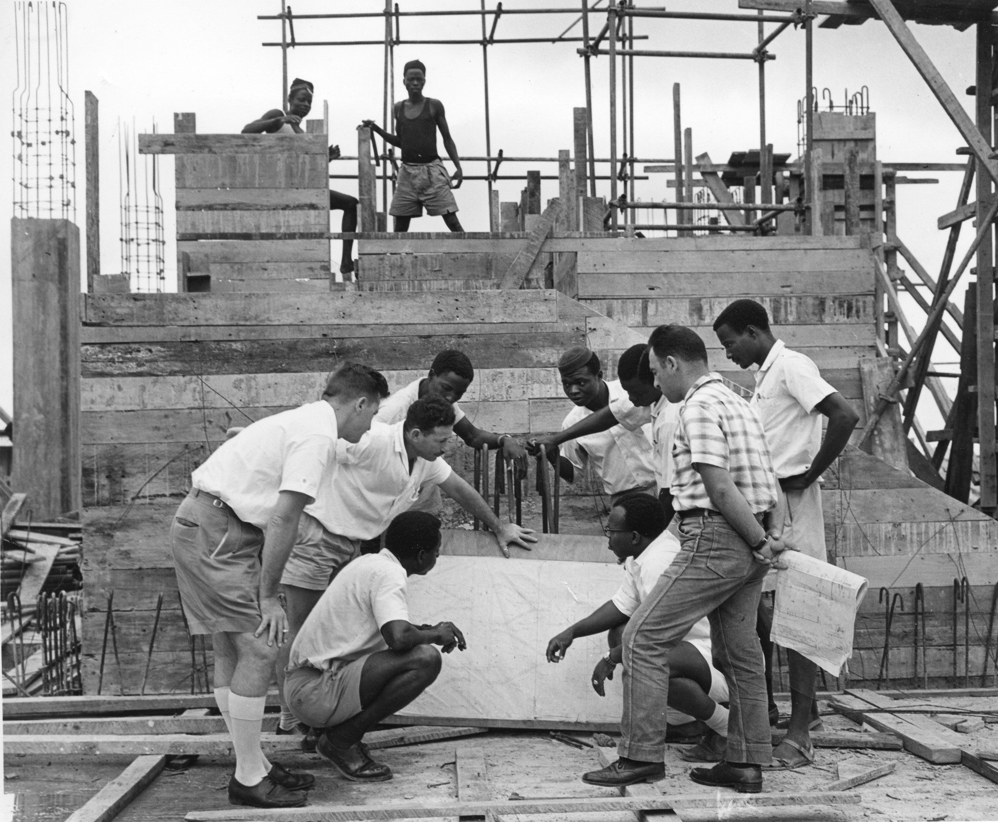 "On-the-spot building course in Nigeria"; Männer stehen vor einem Bauplan auf einer Baustelle
