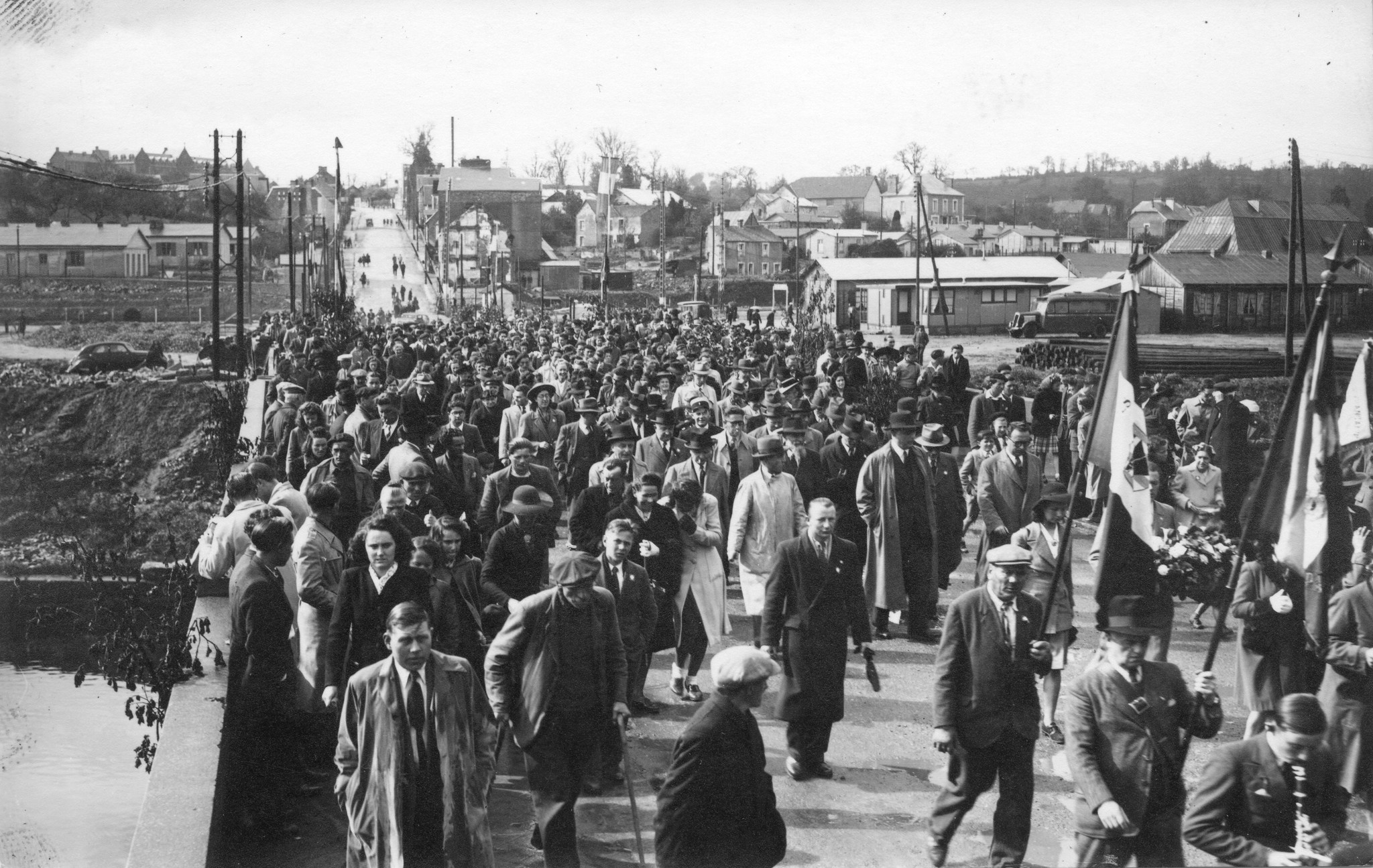 "[Saint-Lô] 4. Mai 1947, Eröffnungstag des Centre social", Menschenumzug, [Sozialzentrum des SAH, "Don Suisse", "Ouvert à toute la population de St-Lô"]
