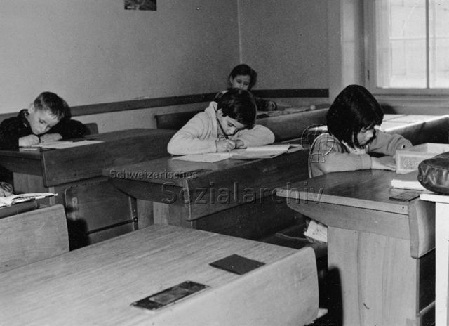 Schule - Kinder hinter der Schulbank beim Schreiben; um 1965