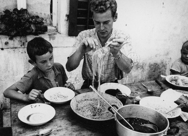 PraktikantInnenhilfe - Praktikant am Tisch beim Nudelnschöpfen; um 1965
