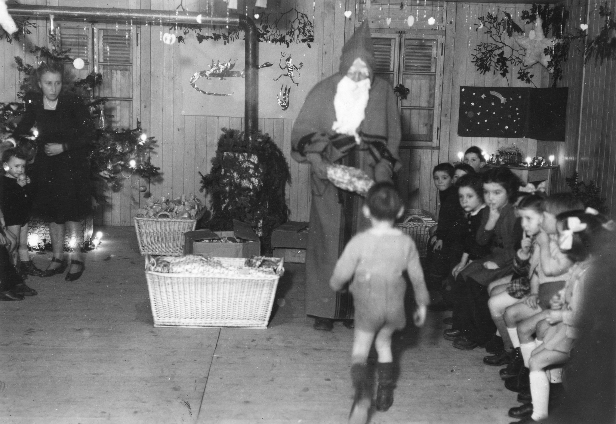 "Saint-Lô [1946] Fête de Noël au Centre Social." ein Weihnachtsmann verteilt den Kindern Geschenke, [Sozialzentrum des SAH, "Ouvert à toute la population de St-Lô"]