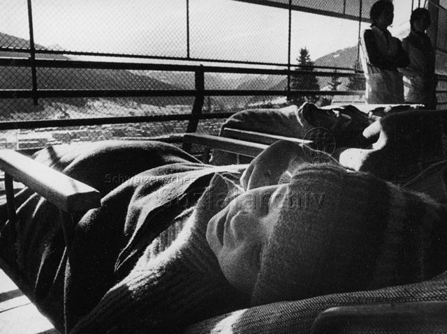 "Kinderheilstätte [Davos], Liegekur" - Kinder liegen, gut zugedeckt und eingekleidet, draussen; 1971