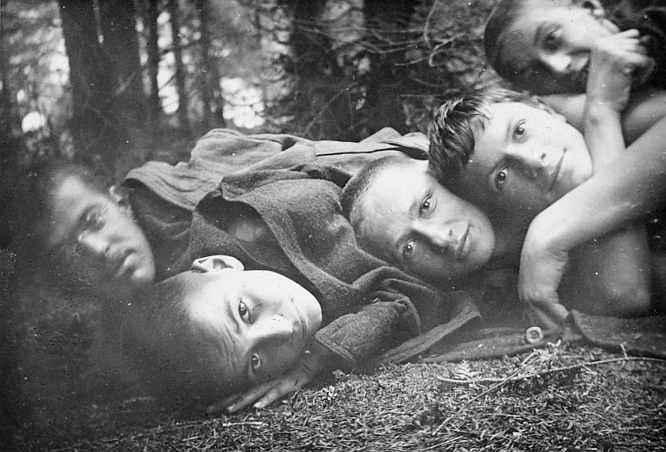 Schutz vor kaltem Regen - Grossaufnahme von im Wald liegenden Wandervögeln (1920)