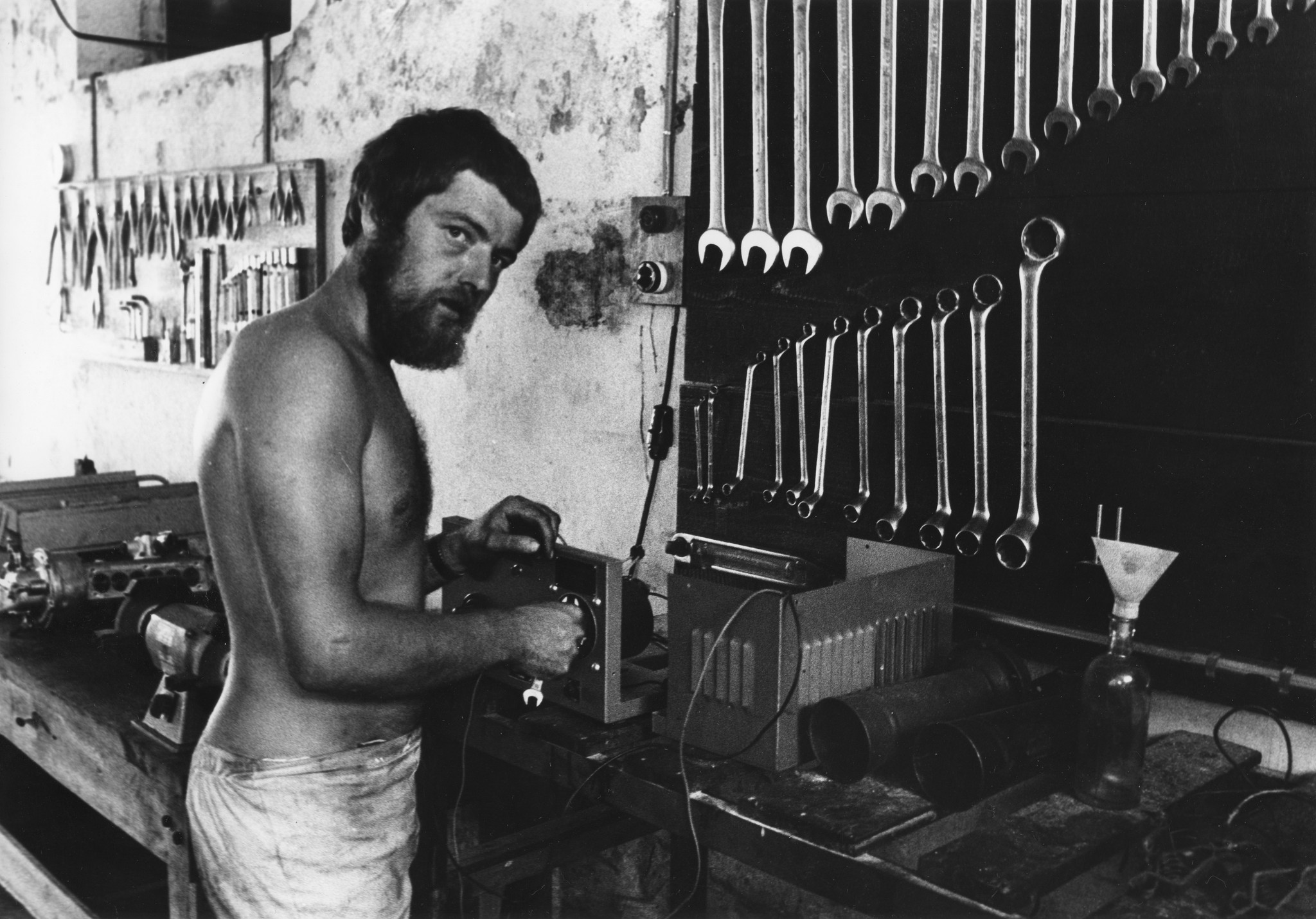 "Bangladesh: Swiss Truck Team Oktober 1972"; Lastwagenteile werden von einem Schweizer Mechaniker in einer Fahrzeuggarage repariert