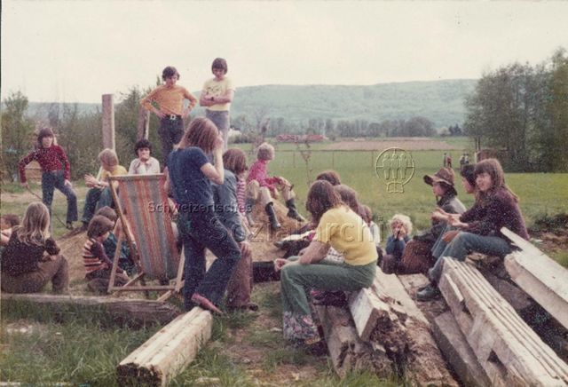 "Robi Therwil" - Kinder sitzen auf Spielplatz beisammen; 1976