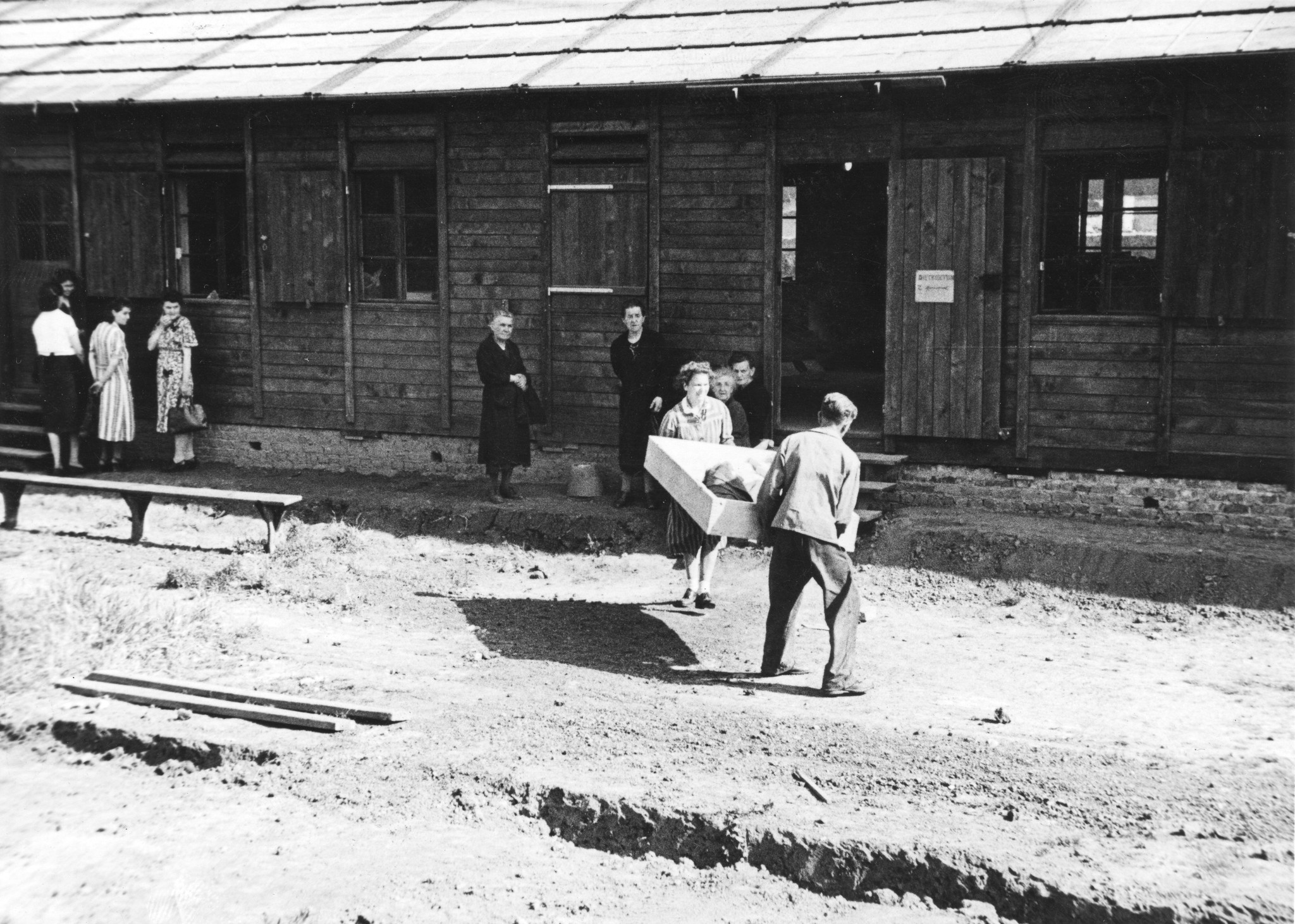 "Fives [Stadtviertel von Lille, Nord-Pas-de-Calais] Möbelverteilung", eine Frau und ein Mann tragen einen Möbelstück, vermutlich im SAH-Sozialzentrum, um 1946