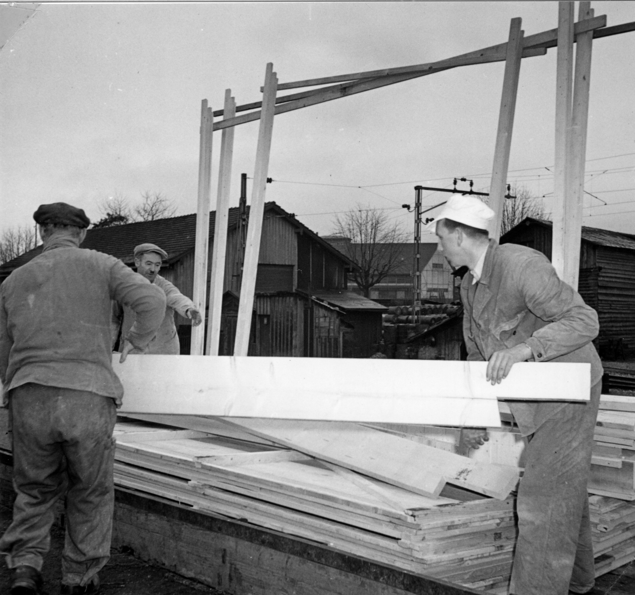 Kohle/Holz: Männer setzen ein Holzgerüst zusammen