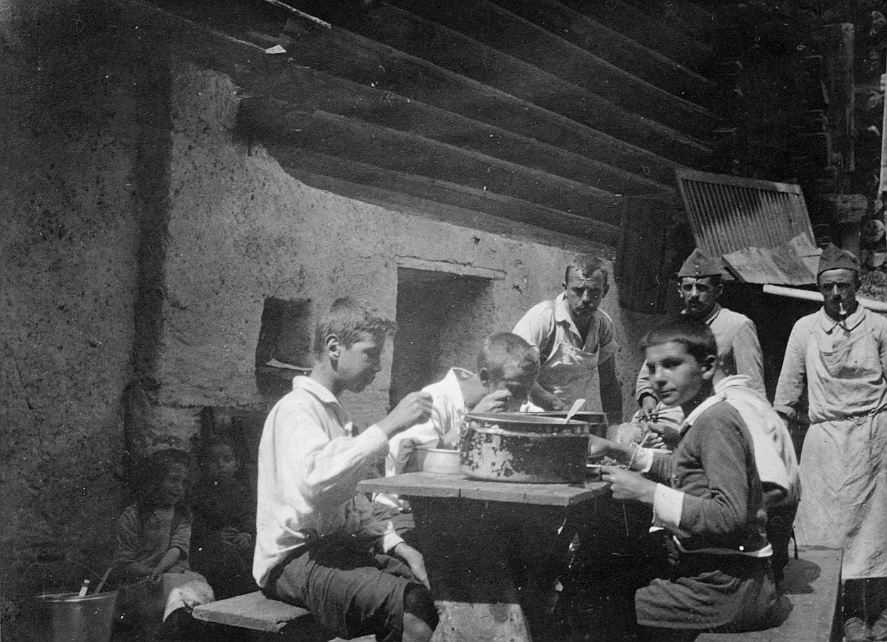 Polla zu Hosverlorn und Glünggi von Hosladow beim Soldatenschlamm - Wandervögel sitzen am Tisch und essen aus ihren Essnäpfen (1920)