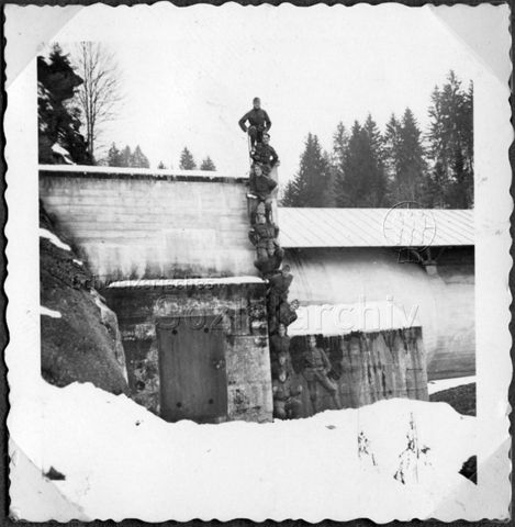 Album Alfred Brauchli, Teil 1/3: 699 Tage Aktivdienst 1939-1945 als Sanitätssoldat bei der Sanitätskompanie I/​7, Thurgau: - Gruppenfoto von Soldaten in Uniform auf Leiter bei einem Bunker im Winter