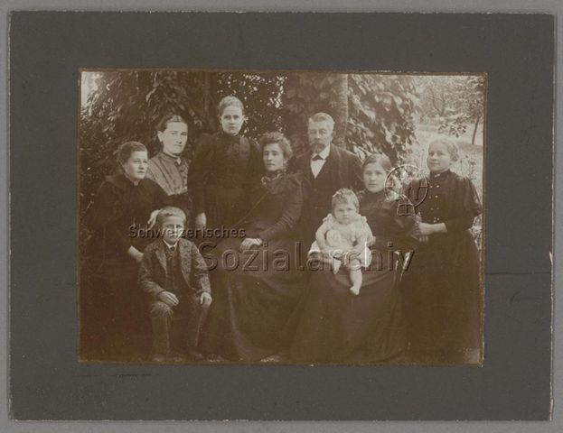 Familienfoto im Freien, hineinmontierte Person (2.v.l.), um 1900