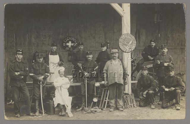 Männer in Militäruniformen, Werkzeuge, Kochgeschirr/Gamelle, Säbel, Tafeln "Escadron No. 2", "Synode et Fabrique de Spatz", um 1915