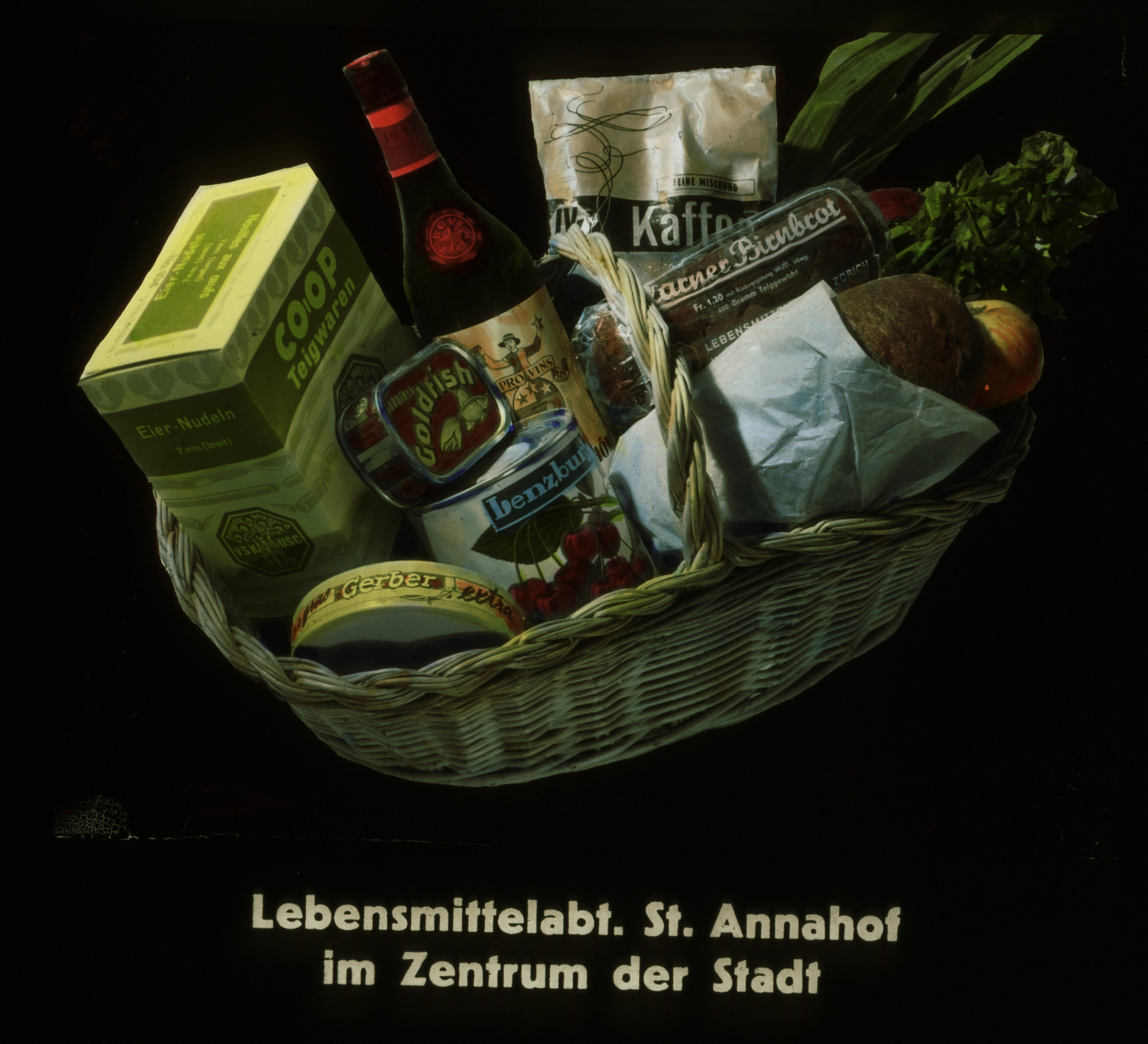 Dia: Korb mit Lebensmitteln, dazu Text: "Lebensmittelabt. St. Annahof im Zentrum der Stadt".