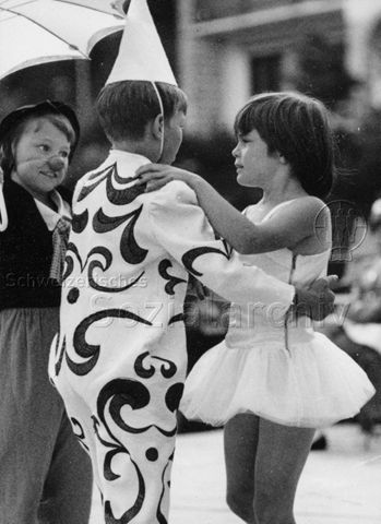 "FZA Zirkus" - Ein Junge und ein Mädchen tanzen, links hinten ein Mädchen verkleidet als Clown; um 1970