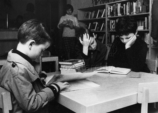 Bibliothek - Kinder beim Stöbern und Lesen; um 1965