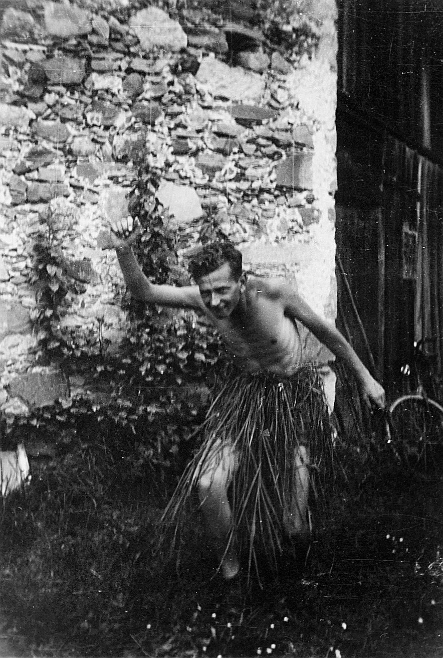 Nackter Wandervogel mit einem Strohrock tanzend (vermutlich) - Im Hintergrund ist ein parkiertes Velo sichtbar (Juni 1932)