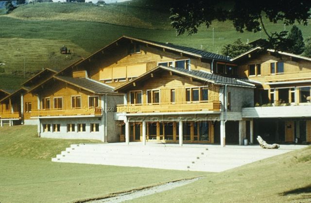 "Ferienkolonien: Ferienkolonie Château d'Oeux" - Aneinandergebaute Häuser im Chalet-Stil in ländlicher Umgebung