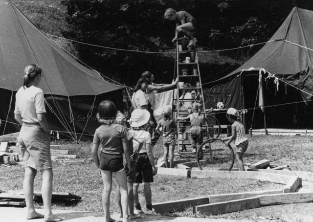 Kinder spielen im Parcours, beaufsichtigt von Erwachsenen; um 1980