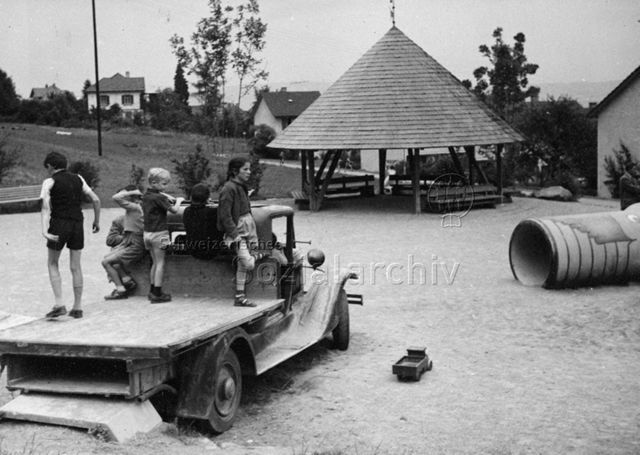 Spielplatz, Siedlung Sonnengarten, Zürich - Kinder beim Spielen auf einem alten Transportfahrzeug; um 1960