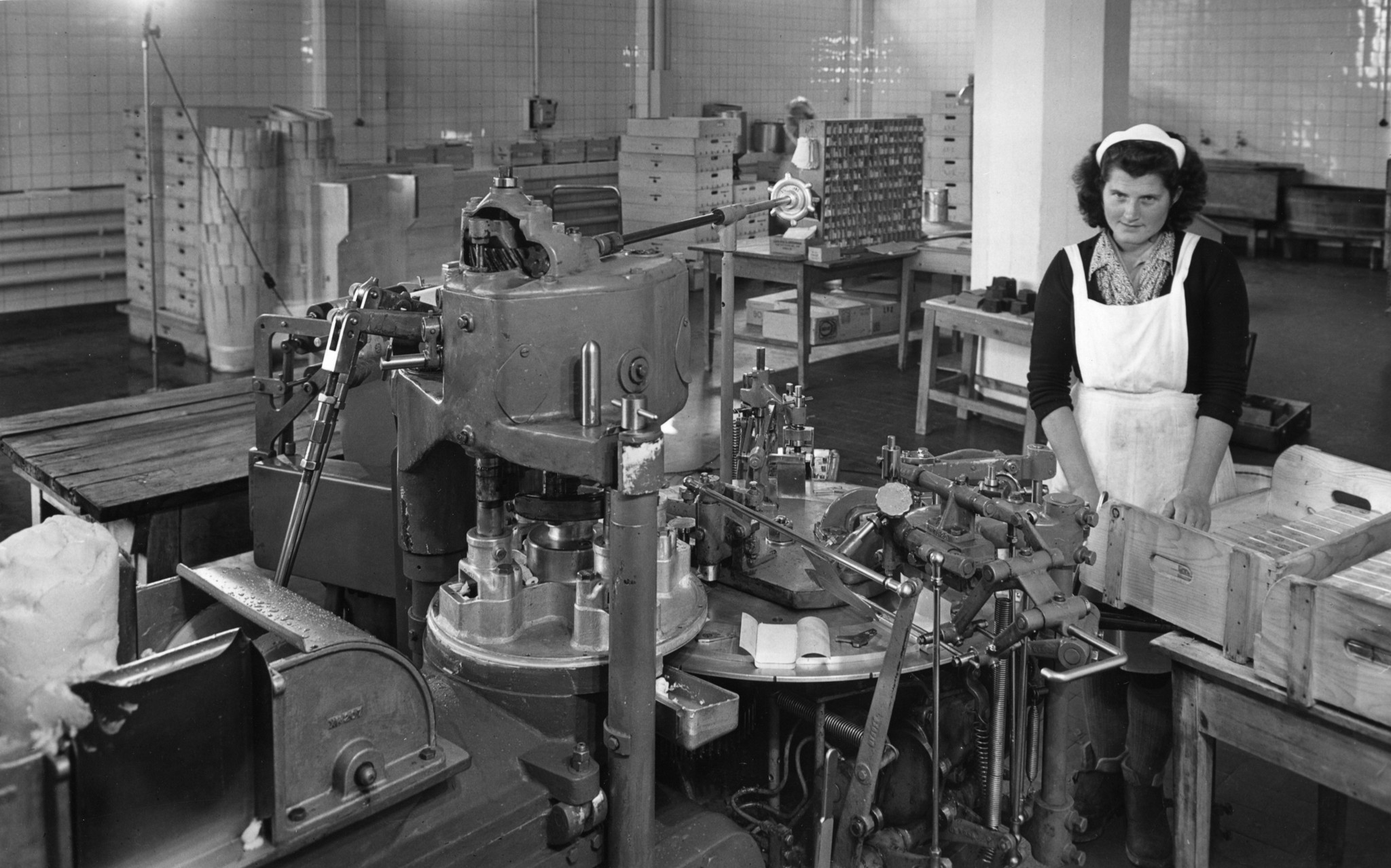 Frau an einer Verpackungsmaschine für Butter