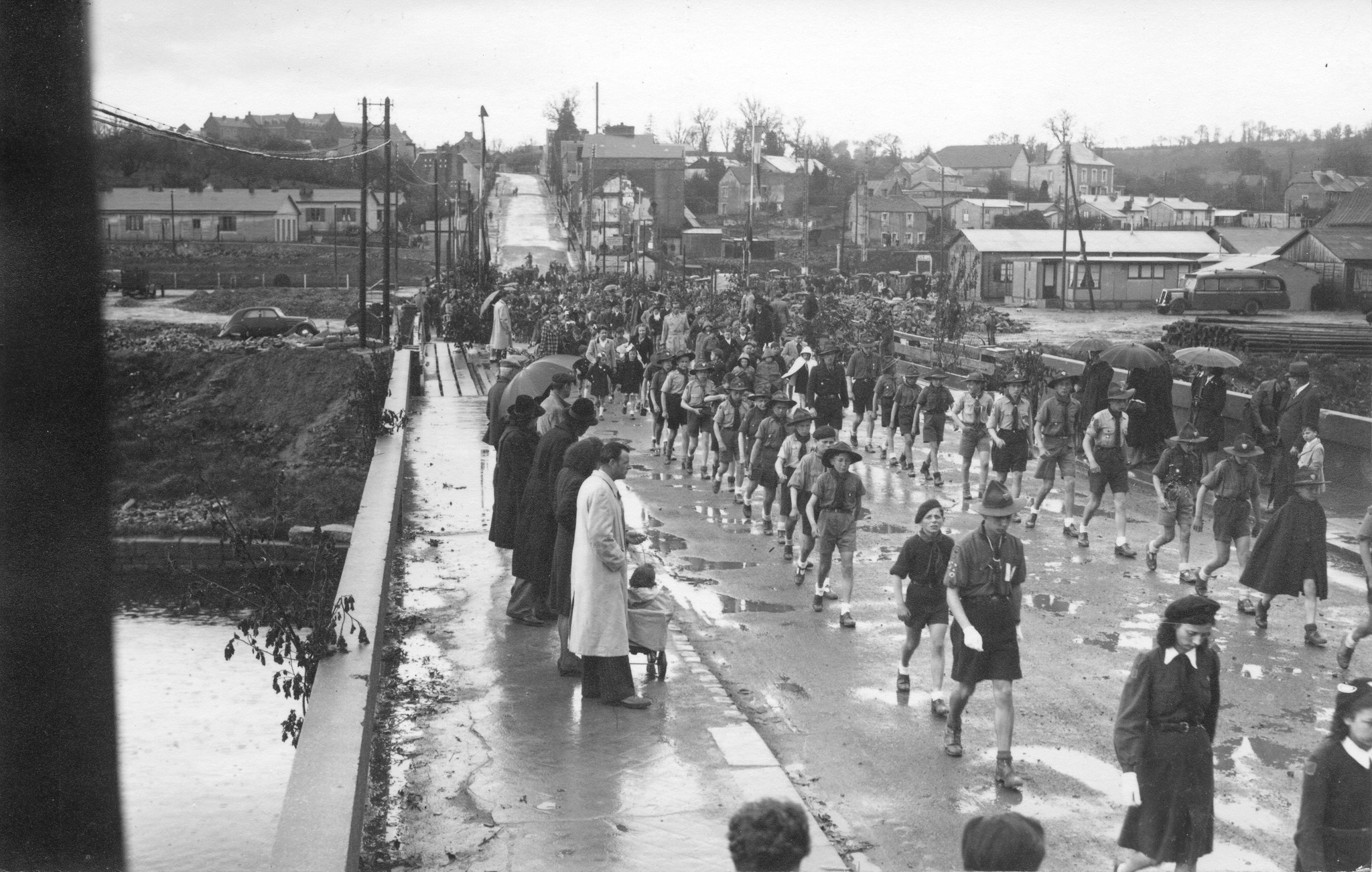 "[Saint-Lô] 4. Mai 1947, Eröffnungstag des Centre social", Menschenumzug  mit Pfadfindern, [Sozialzentrum des SAH, "Don Suisse", "Ouvert à toute la population de St-Lô"]