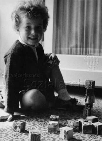 "Kinderbildnisse" - Kleines Mädchen beim Spielen mit Würfeln; um 1960