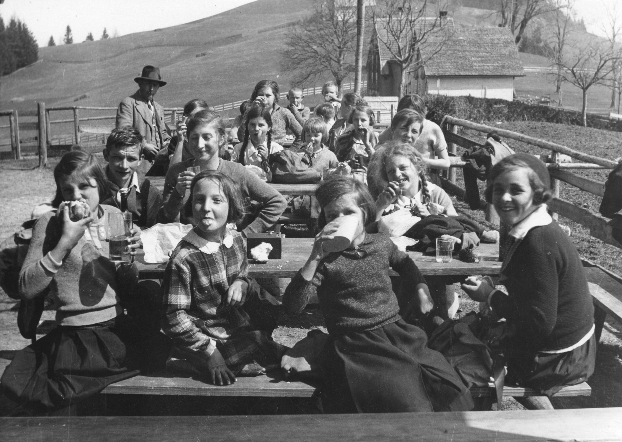 Kinder der Steyrerkinder-Aktion [vermutlich aus Steyr (Oberösterreich)] schneiden Grimassen während einer Mittagspause in ländlicher Umgebung, auf dem Gräbis [nah Gais (AR)], um 1950 (Nachkriegszeit)