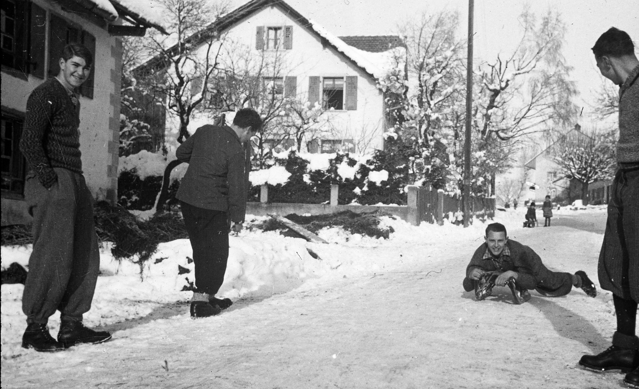 Winterstimmung: Junge Männer auf der Strasse und beim Schlitteln