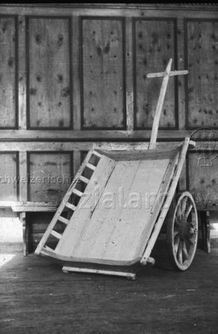 "Wagnerei und Bootbau: Handwagen" - Ein aus Holz gefertigter Handwagen lehnt an der Wand