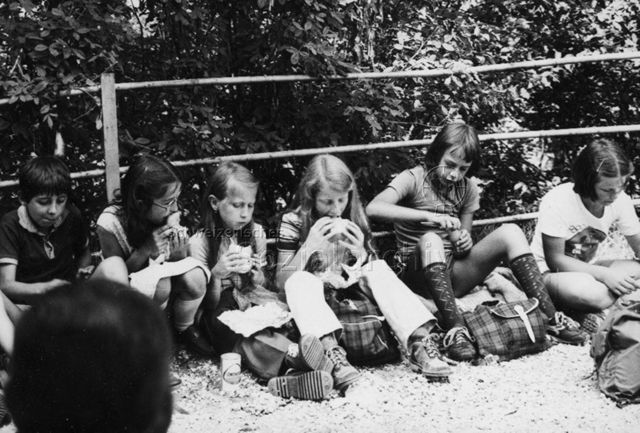 Kinder auf dem Boden sitzend beim Picknick; um 1980