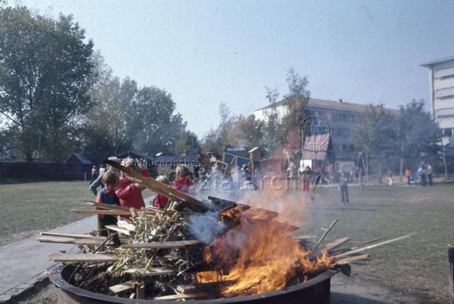 "Robinsonspielplatz Bachgraben, Basel" - Kinder beim Verbrennen von Ästen und Brettern; um 1970
