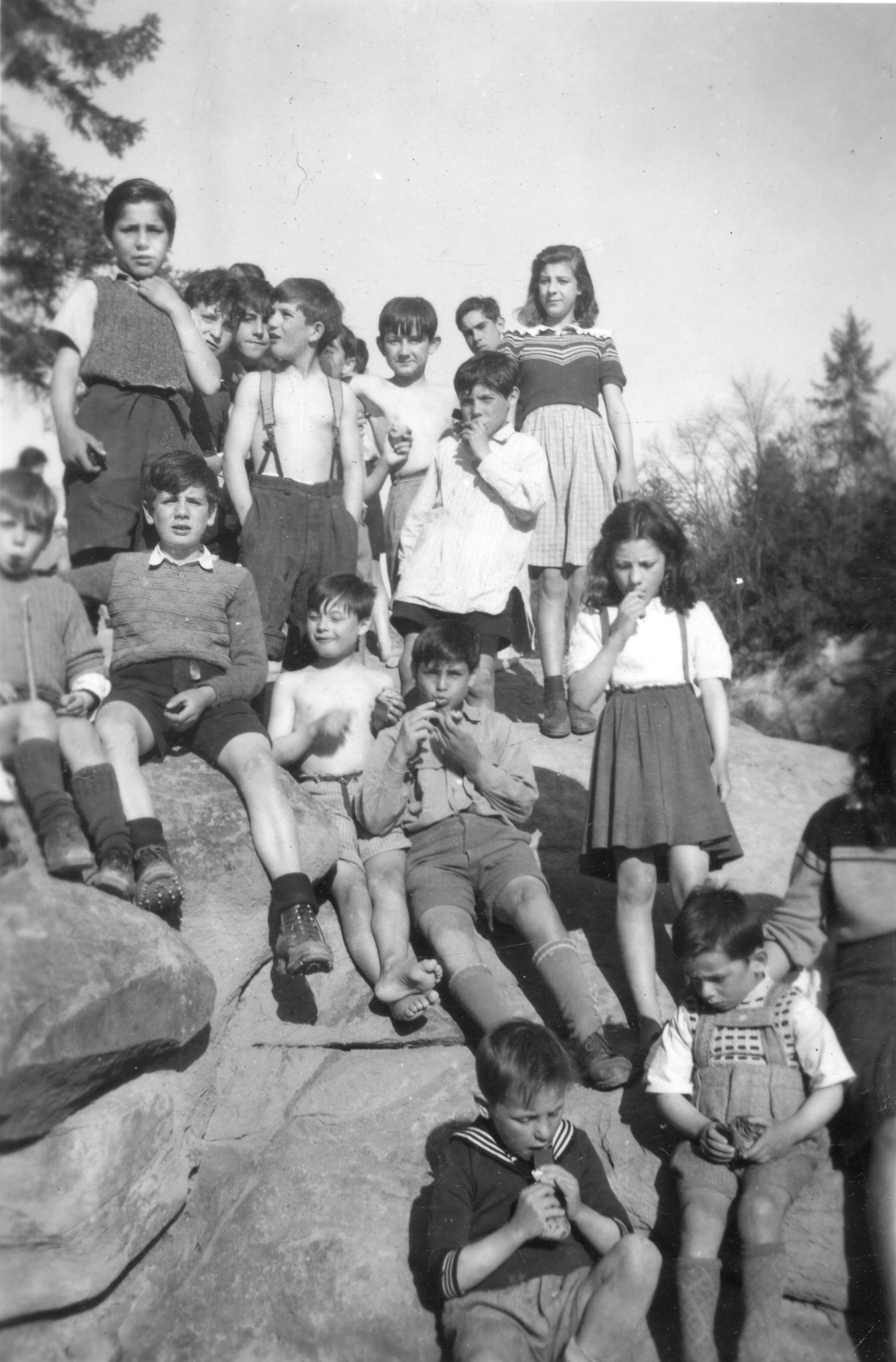 Gruppenfoto von Kindern die auf grossen Steinen sitzen oder stehen