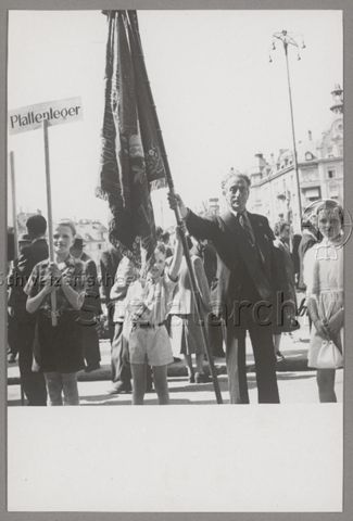 1. Mai, Mann mit Fahne, Knabe mit Tafel "Plattenleger", um 1960