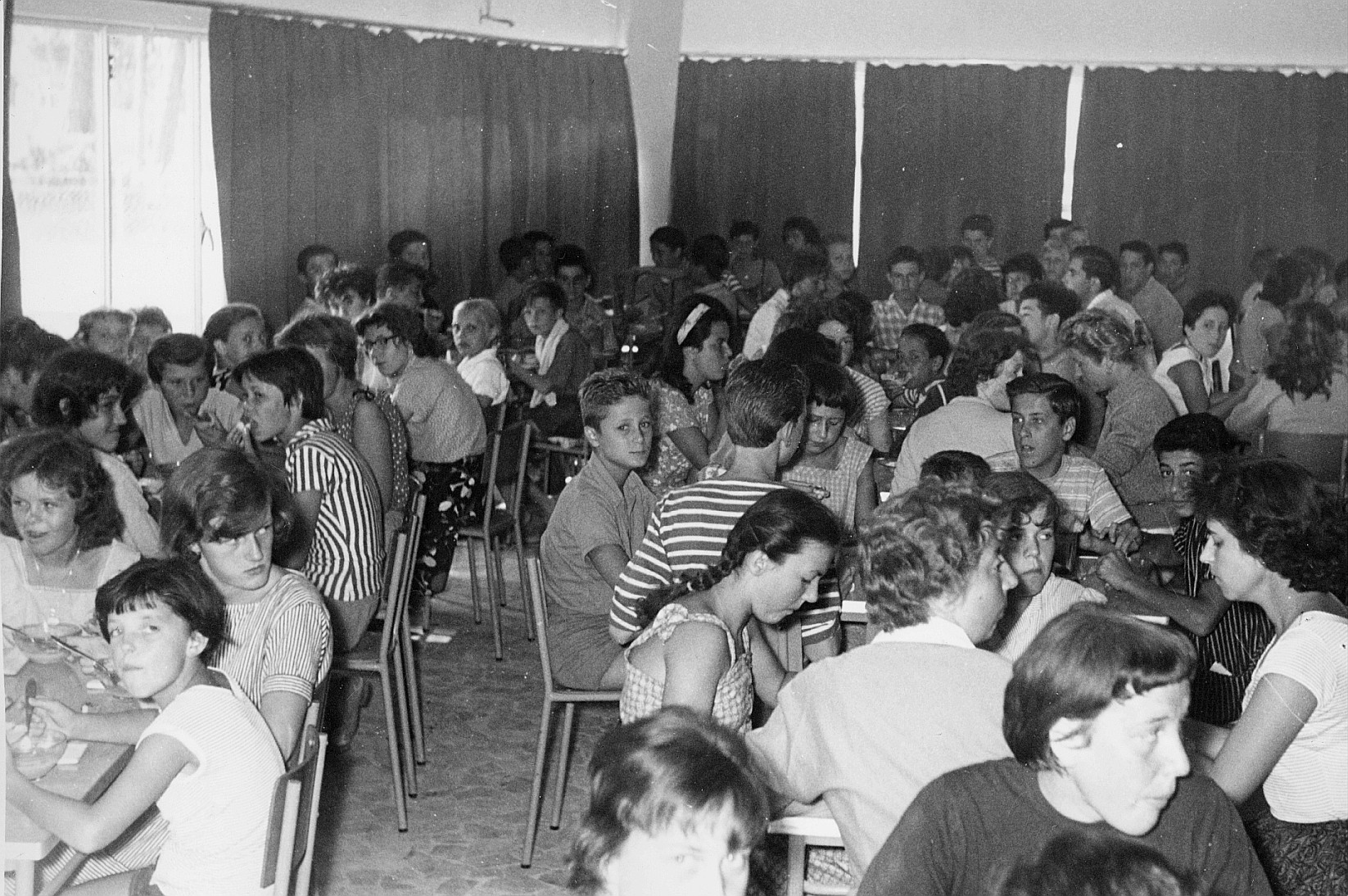 Internationales Kindertreffen in Cervia, Sommer 1958; Kinder in einem Saal an Tisch sitzend und essend