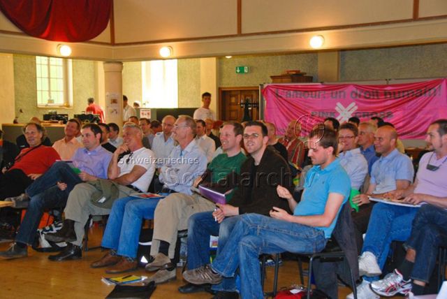 Generalversammlung des Pink Cross (2009) – Verbandsmitglieder, Transparent im Hintergrund: "L'amour: un droit humain! – Pink Cross"