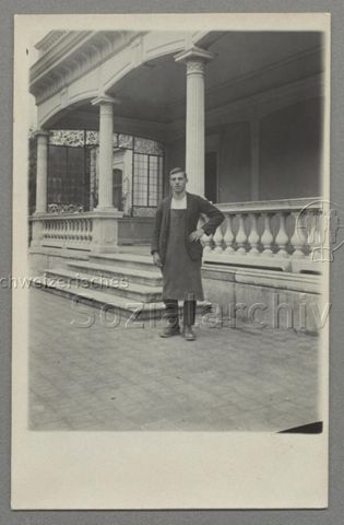 Page / Küchenhilfe (?) vor Veranda mit Säulen, um 1920