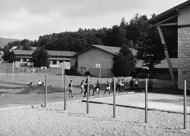 Jugendliche beim Kugelstossen auf einem Schulsportplatz; um 1965