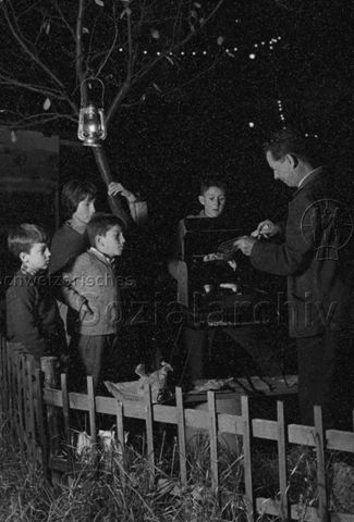 "Robinsonspielplatz Heuried" - Vier Kinder und ein Mann beim Grillen; um 1970