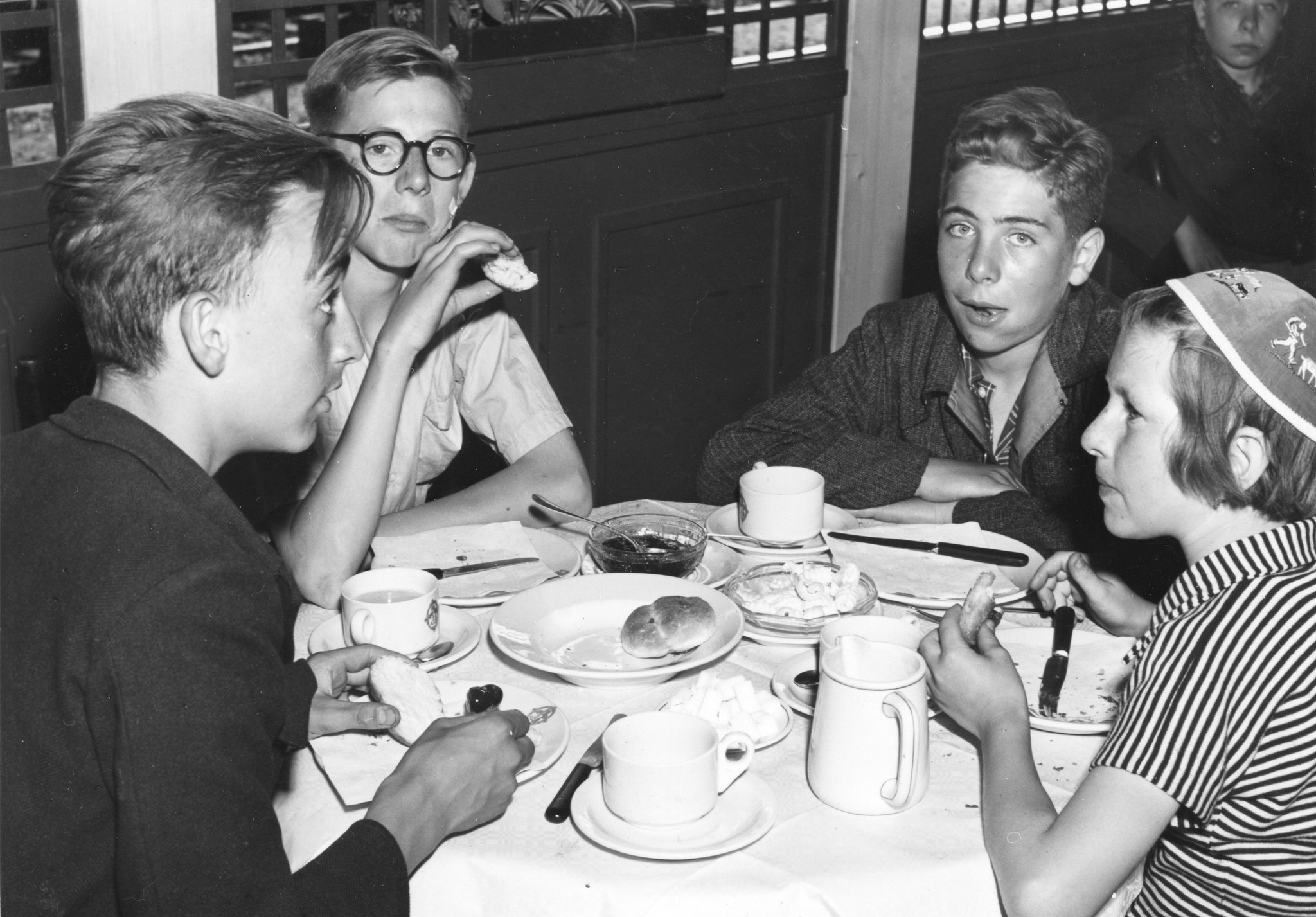 "Belgierkolonie Sommer 1950, Abreise in Basel"; Kinder essen Semmel und trinken Schokolade
