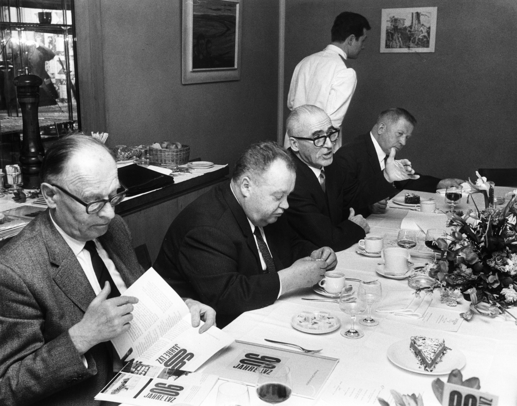 Jubiläum 100 Jahre Lebensmittelverein Zürich 1978: Männer sprechen bei einem Essen miteinander