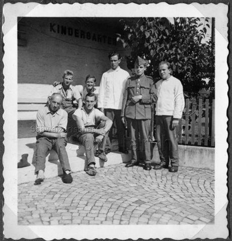 Album Alfred Brauchli, Teil 1/3: 699 Tage Aktivdienst 1939-1945 als Sanitätssoldat bei der Sanitätskompanie I/​7, Thurgau:- Alfred Brauchli (rechts) vor einem Gebäude, das mit "Kindergarten" beschriftet ist