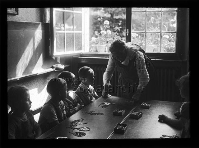 Diaserie zum Thema Kindergarten; Kinder und Betreuerin fertigen Bilder aus Kleiderknöpfen; um 1930
