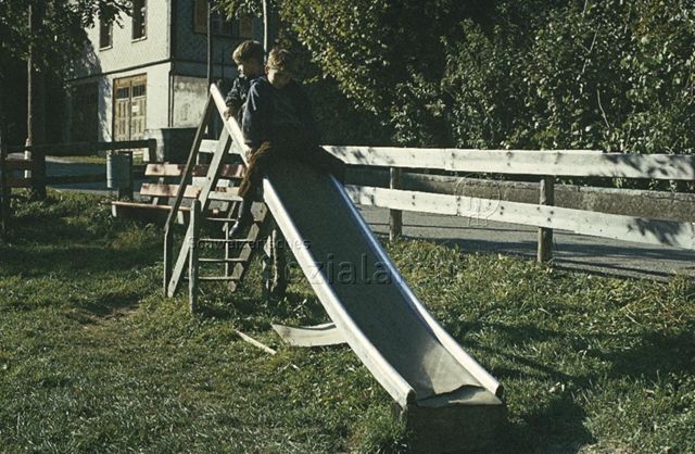 "Rutschbahn, Kinderspielplatz Brunnadern" - Zwei Jungen beim Rutschen; um 1975